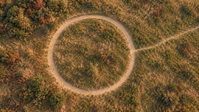 Worn circular footpath with a single faint trail breaking away, representing the question of whether free will is an illusion. | wellbeing blog | new empowered you hypnotherapy the hague wassenaar online